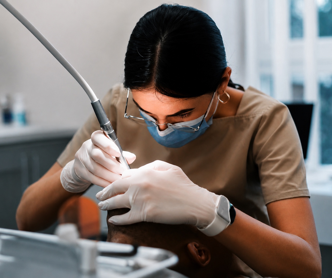 A practitioner focused on a gentle ultrasonic treatment in a bright practice